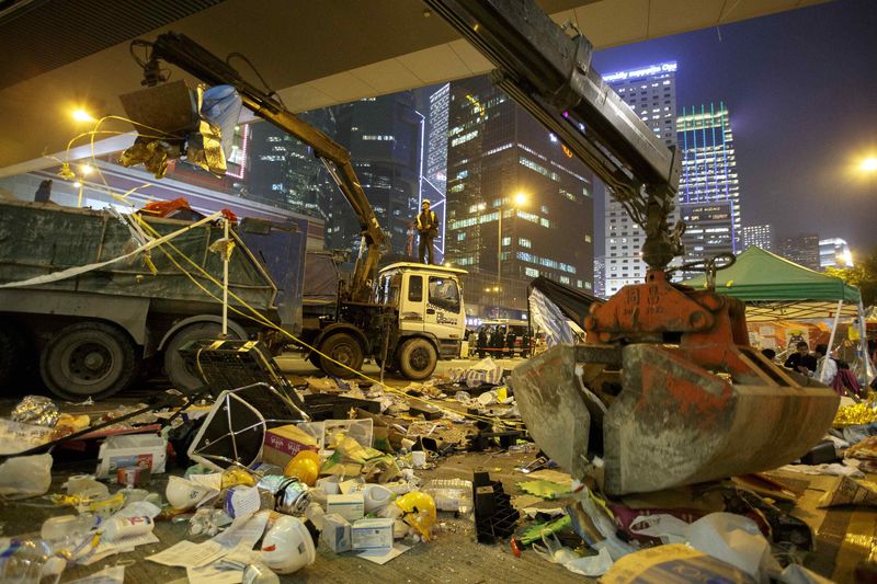 © Reuters. Cranes remove tents and wood near the government headquarters building at the financial Central district in Hong Kong