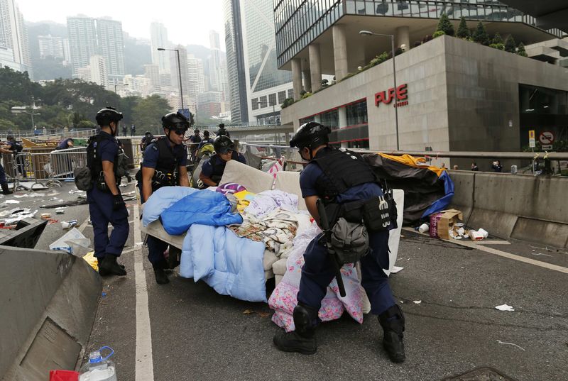 © Reuters. Police remove a sofa as they clear an area previously blocked by pro-democracy protesters near the government headquarters building at the financial Central district in Hong Kong