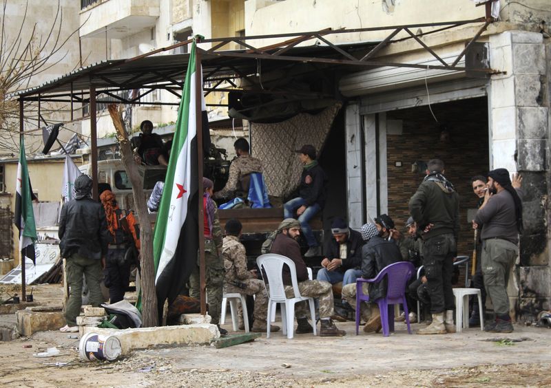 © Reuters. Rebel fighters rest near frontline in al-Breij district of Aleppo