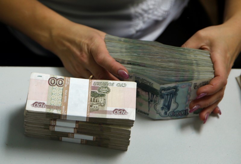 © Reuters. An employee of a bank counts rouble banknotes in Moscow