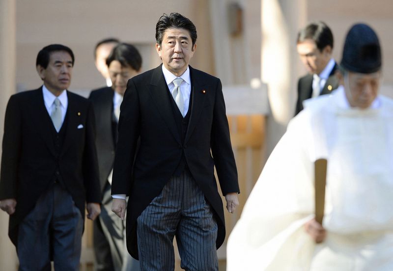 © Reuters. File photo of Abe led by a shinto priest as he pays a customary New Year's visit at Ise shrine in Ise