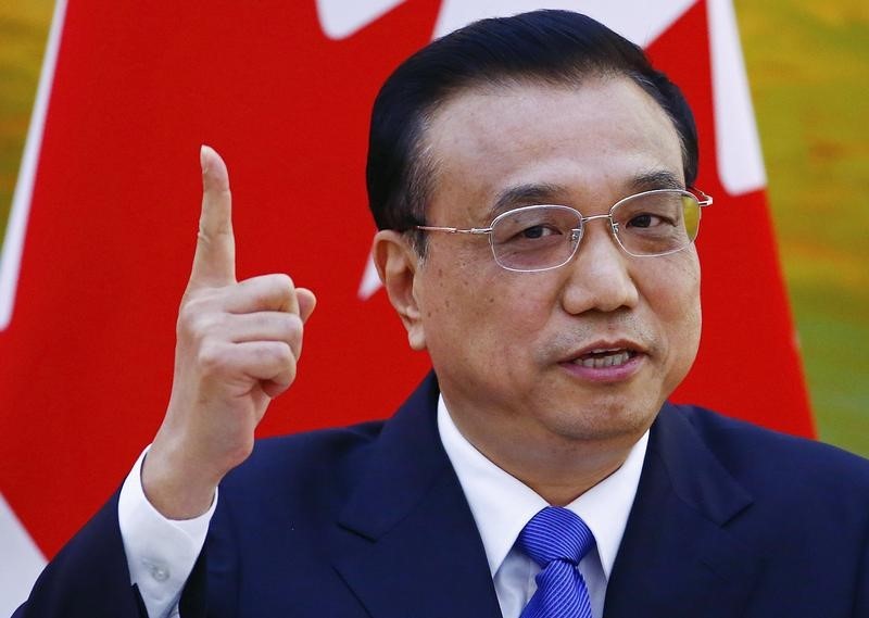 © Reuters. China's Premier Li gestures in front of a Canadian national flag during a joint news conference at the Great Hall of the People in Beijing