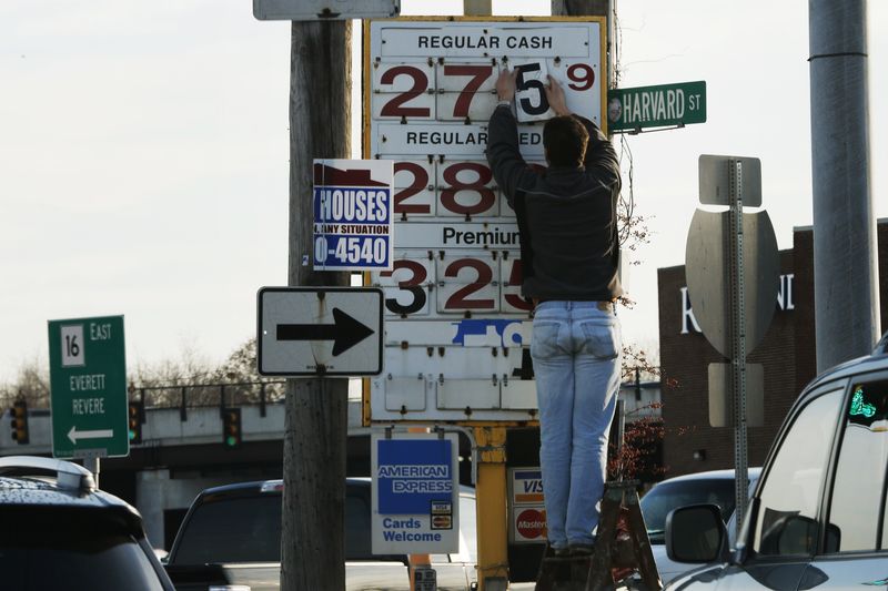 © Reuters. A man changes the price for a gallon of gasoline at a gas station in Medford