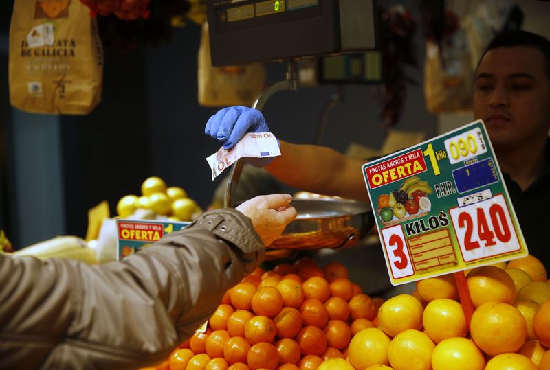 © Reuters. A fresh produce vendor sells fruits to a customer at a market in central Madrid