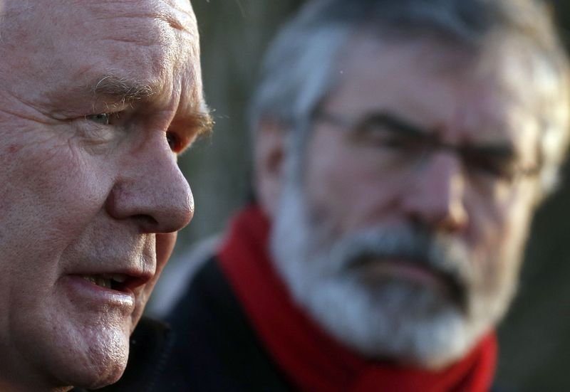 © Reuters. Sinn Fein's Gerry Adams watches Martin McGuinness speak to the press outside Stormont House after Ireland's Taoiseach Enda Kenny and Britain's Prime Minister David Cameron left talks with Northern Ireland's political parties at Stormont House in Belfast