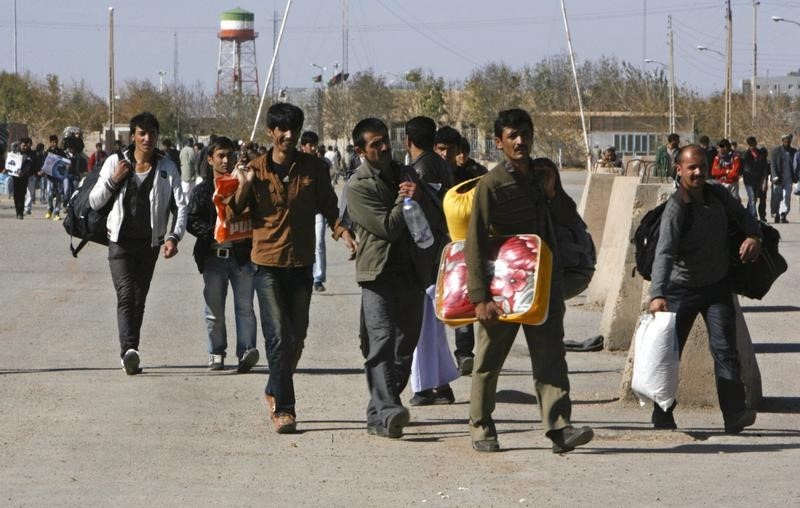 © Reuters. Group of Afghan migrant workers enter Afghan territory after leaving Iran at the Islam Qala border in Herat province