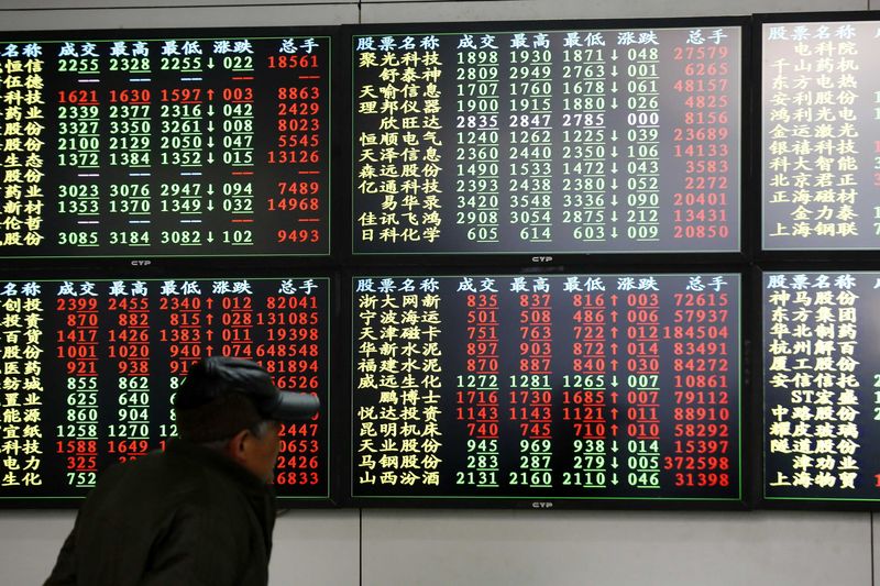 © Reuters. An investor looks at information displayed on an electronic screen at a brokerage house in Shanghai