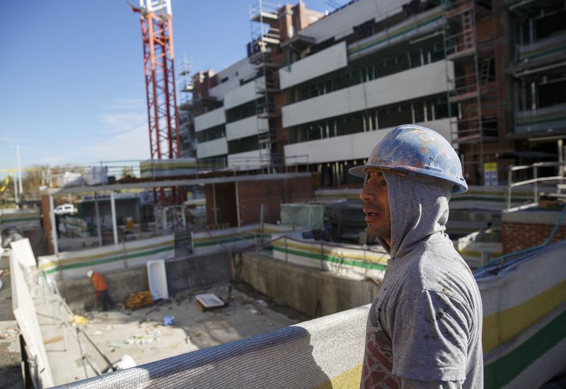 © Reuters. A worker looks over a construction site of a residential block in the Valdebebas neighbourhood in Madrid