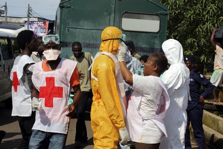 © Reuters. A health worker fixes another health worker's  protective suit in the Aberdeen district of Freetown