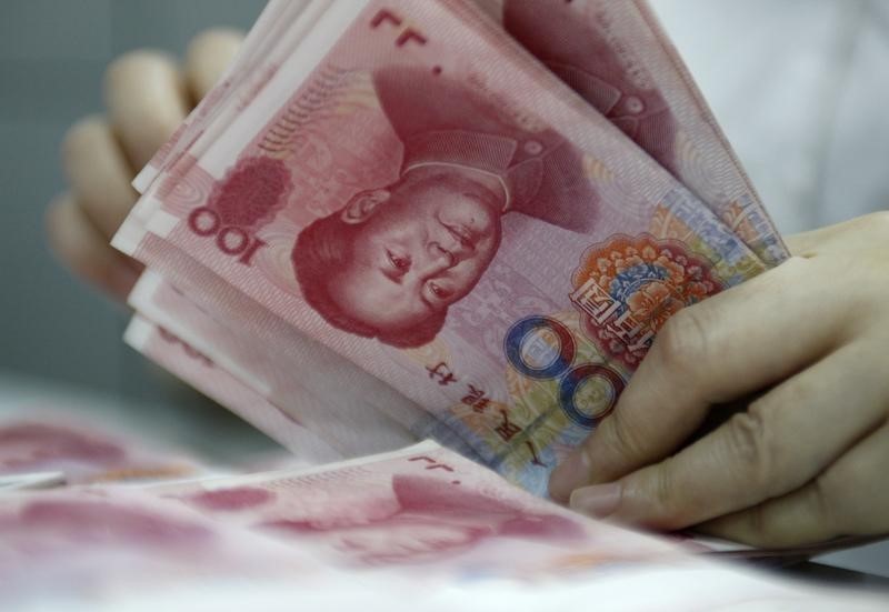 © Reuters. An employee counts yuan banknotes at a bank in Huaibei
