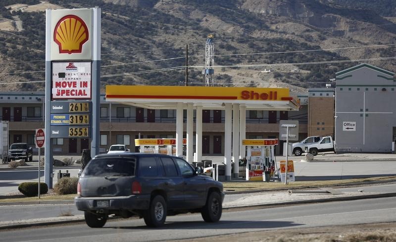 © Reuters. A gas station within view of a WPX Energy natural gas drilling rig in Parachute, Colorado