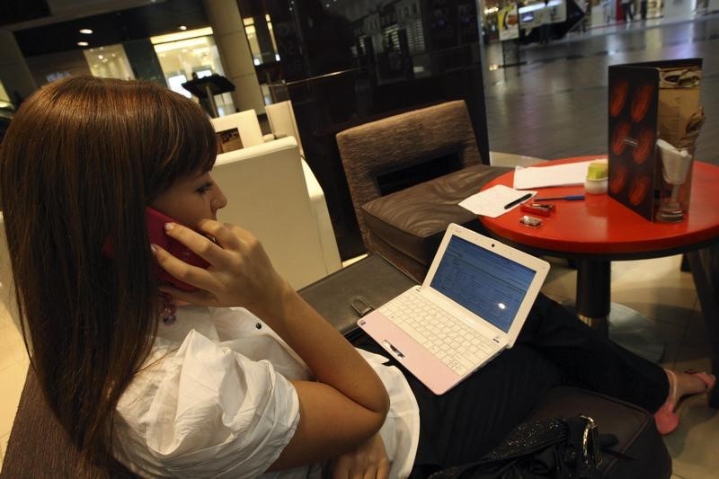 © Reuters. Woman speaks on her BlackBerry mobile phone at a shopping mall in Dubai