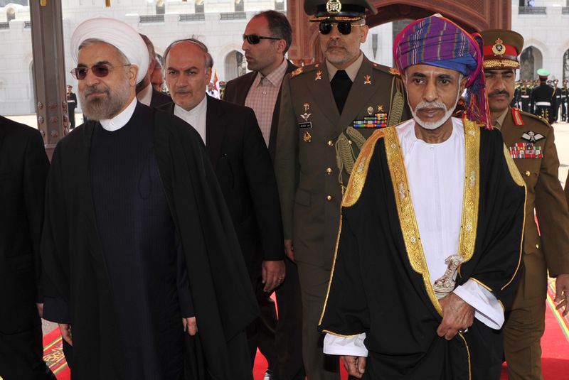 © Reuters. File photo of Oman's Sultan Qaboos bin Said walking with Iran's President Hassan Rouhani upon Rouhani's arrival in Muscat