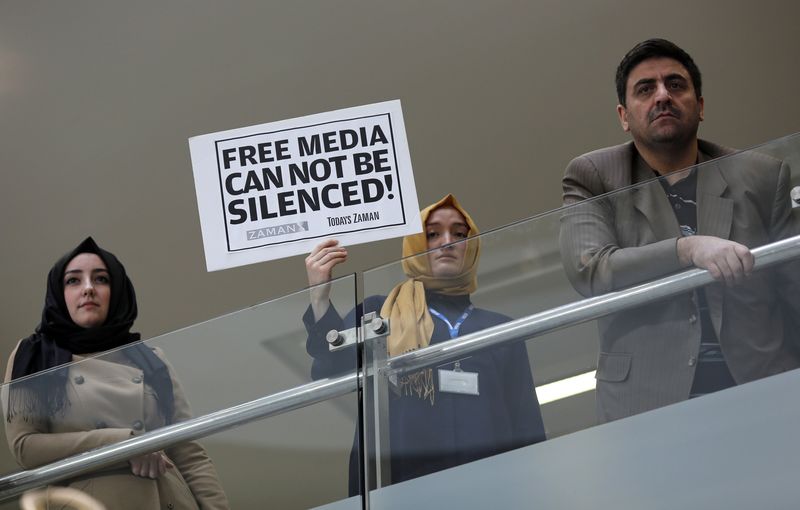 © Reuters. A Zaman journalist holds a placard at the headquarters of  Zaman daily newspaper in Istanbul
