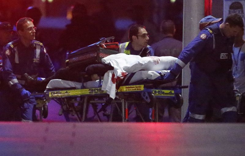 © Reuters. Paramédico retiram pessoa coberta por cobertor manchado de sangue do café Lindt em Sydney, na Austrália