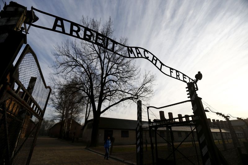 © Reuters. A woman walks near the main gate that reads "Arbeit macht frei" (Work makes you free) of the former Nazi concentration camp Auschwitz-Birkenau in Oswiecim