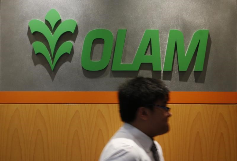 © Reuters. A man walks past a logo of Olam International Limited at its office in Singapore