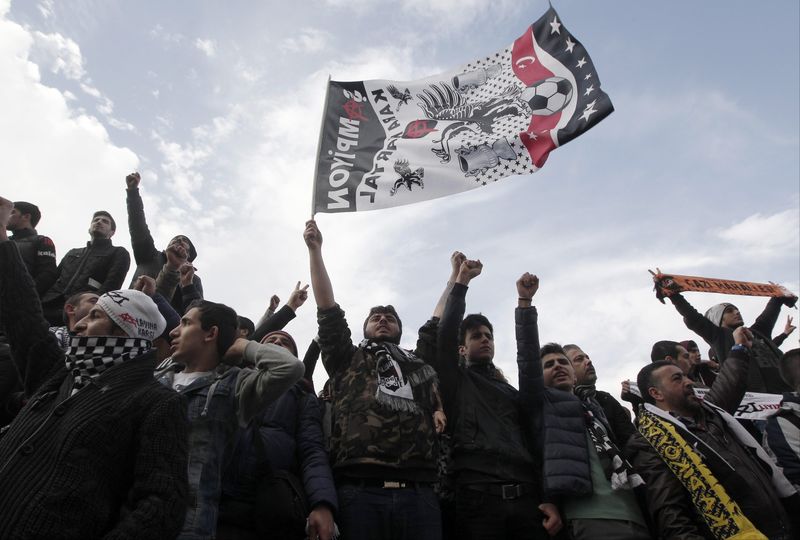 © Reuters. Protesters, who are supporting soccer fans on trial, shout slogans outside a court in Istanbul