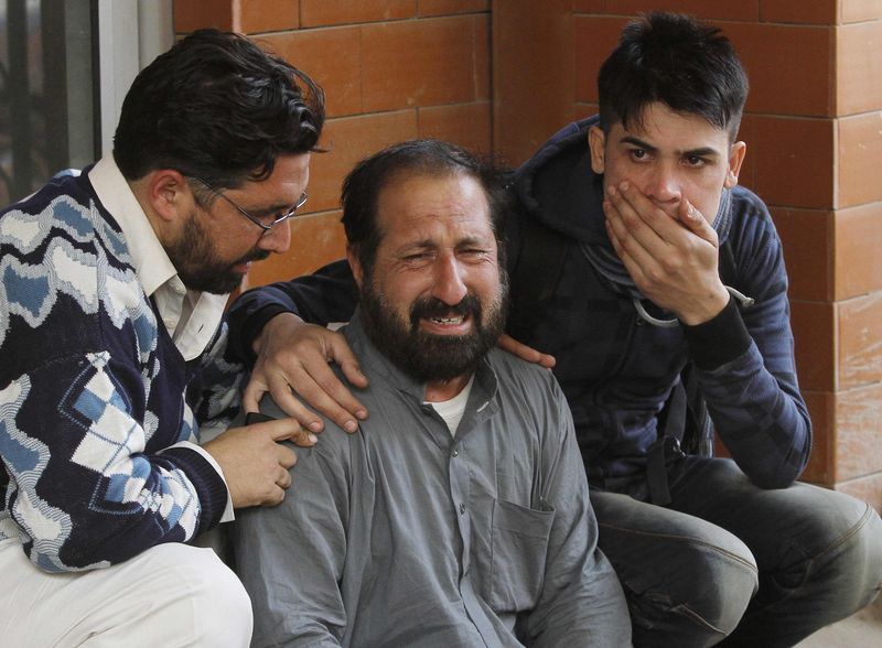 © Reuters. Familiares de um estudante, que foi ferido por ataque do Taliban a uma escola de Peshawar