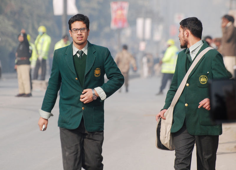 © Reuters. Students walk near the Army Public School that in under attack by Taliban gunmen in Peshawar