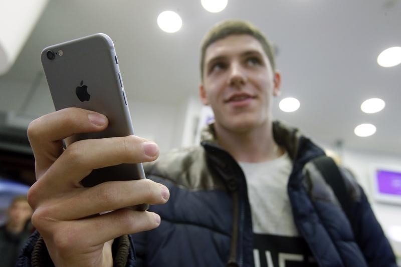 © Reuters. A customer holds the newly released iPhone 6 at a mobile phone shop in Moscow