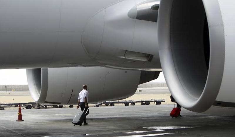 © Reuters. An EgyptAir airline crew member walks near an EgyptAir plane on the runway at Cairo Airport