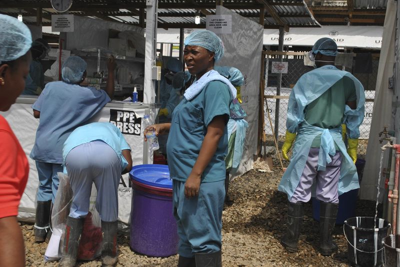 © Reuters. Agentes da saúde entram num centro de tratamento de Ebola na Libéria