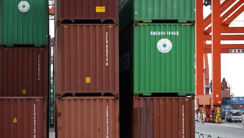 © Reuters. Workers are seen in a container area at a port in Tokyo