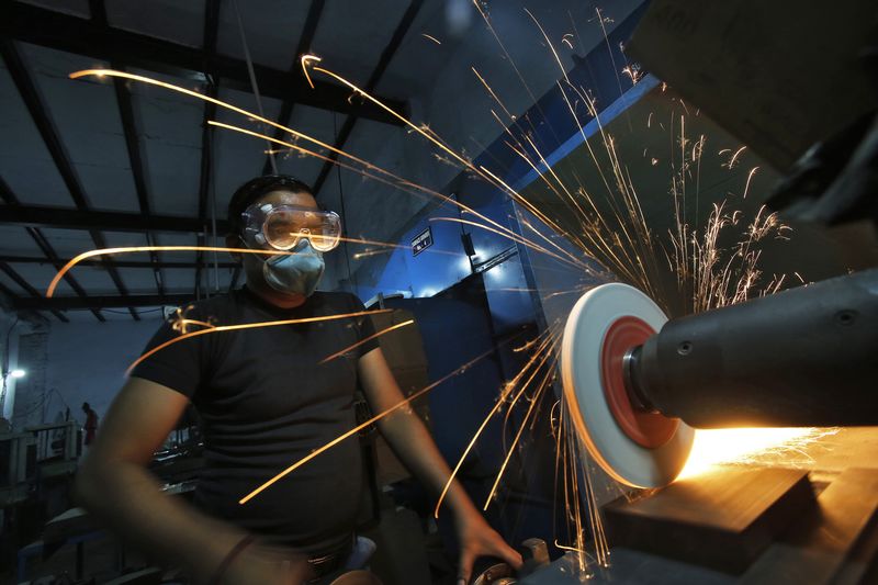 © Reuters. File photo of a worker operating a lathe machine as he makes a steel cutter at a manufacturing unit in Noida