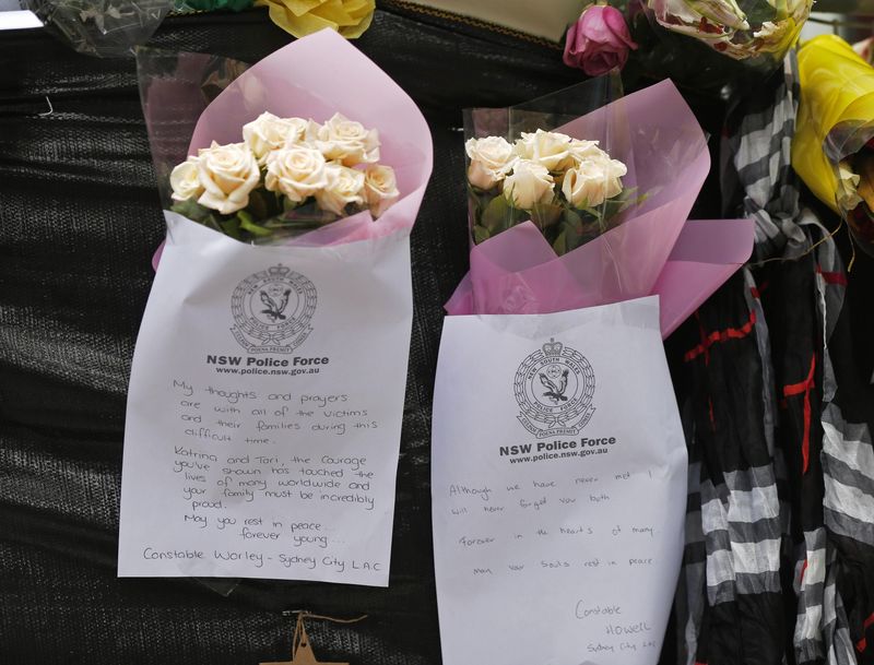 © Reuters. Floral tributes and personal notes written by members of the New South Wales police force are left on a fence near the site of the Sydney cafe siege in Martin Place