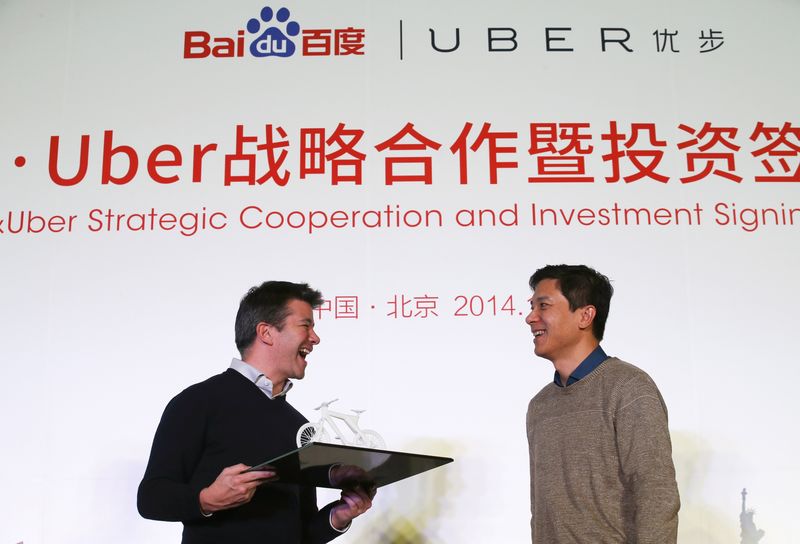 © Reuters. Uber CEO Kalanick smiles after receiving a gift from Baidu Inc. Chairman and CEO Li during the Baidu and Uber strategic cooperation and investment signing ceremony in Beijing