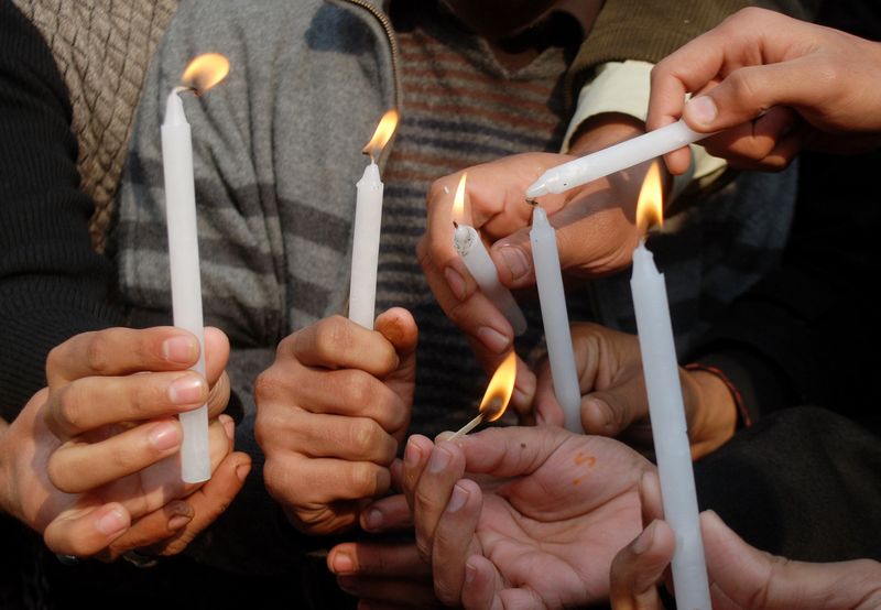 © Reuters. People light candles in memory of victims of the Taliban attack on the Army Public School, during a rally in Peshawar