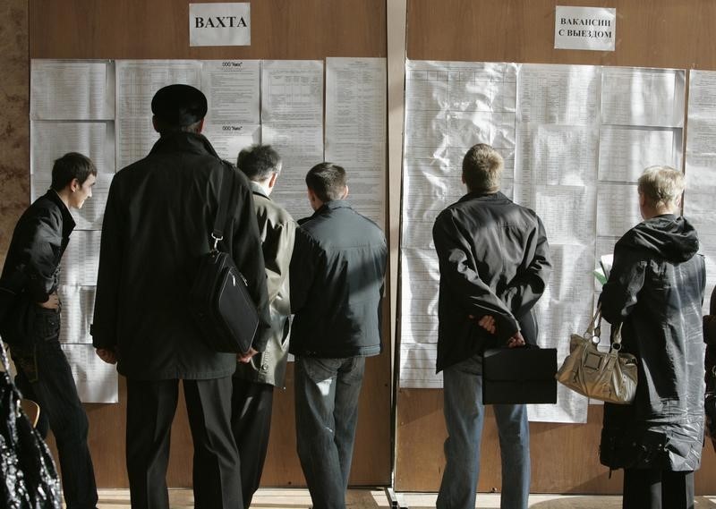 © Reuters. People read lists of vacancies at a job fair in the southern Russian city of Stavropol