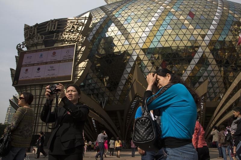 © Reuters. Chinese visitors stand in front of the Casino Lisboa in Macau