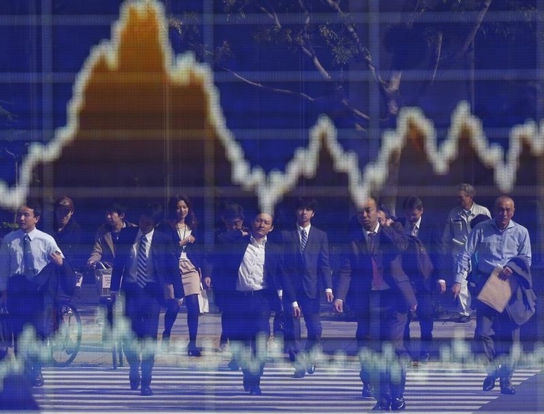 © Reuters. People are reflected on an electronic board displaying a graph showing the movement of Nikkei share average outside a brokerage in Tokyo