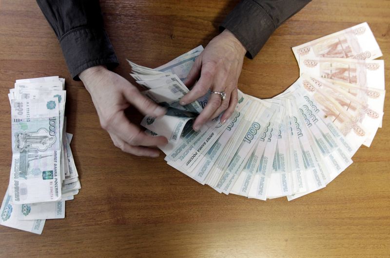 © Reuters. An employee of a local company, producing equipment for electrical meters, counts Russian rouble banknotes in Stavropol
