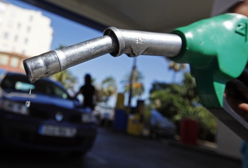 © Reuters.  A customer uses a petrol nozzle to fill up his tank in a gas station in Nice