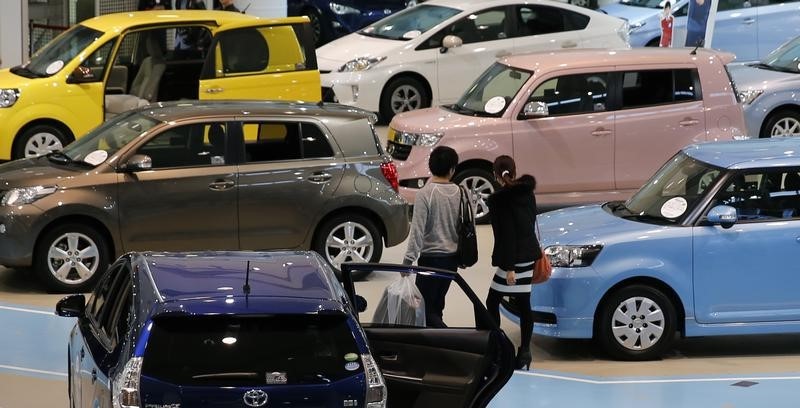© Reuters. Visitors look at Toyota cars at the company's showroom in Tokyo