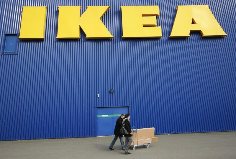 © Reuters. People push a shopping cart past a warehouse of the Swedish furniture maker IKEA in Bordeaux