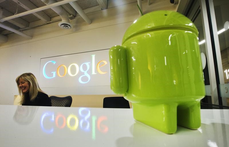 © Reuters. A Google Android figurine sits on the welcome desk as employee McNeilly smiles at the new Google office in Toronto