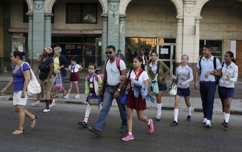 © Reuters. Cubanos atravessam rua em Havana