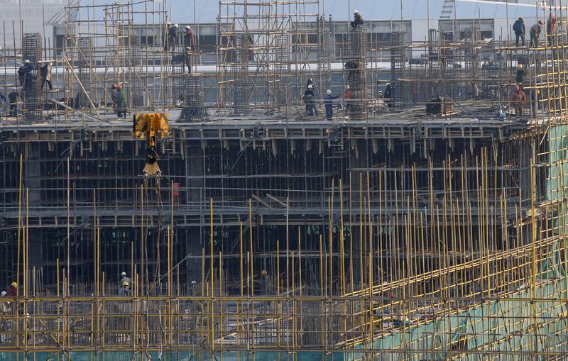 © Reuters. Labourers work at a construction site for a new building in Beijing