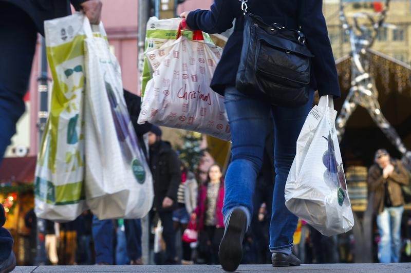 © Reuters. People carry bags outside department store on last day of Christmas shopping in Berlin