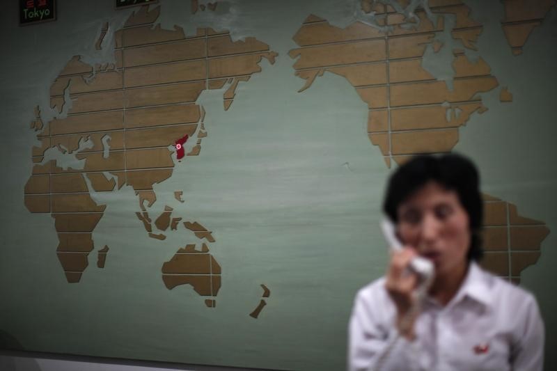 © Reuters. A world map with the Korea peninsula marked in red is seen as a hotel receptionist talks on the phone in Rason city
