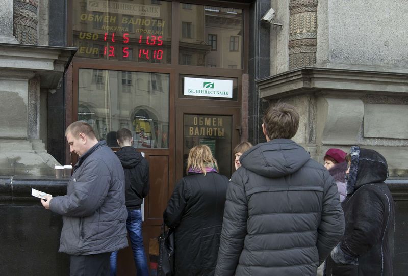 © Reuters. People stand in line to withdraw money at an ATM of a bank in central Minsk