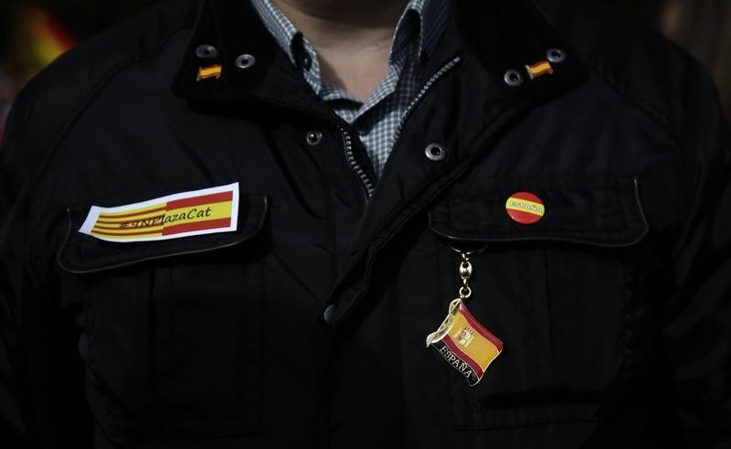 © Reuters. A Spanish unionist with Spanish merchandising attends a protest in Madrid against a symbolic independence vote in Catalonia