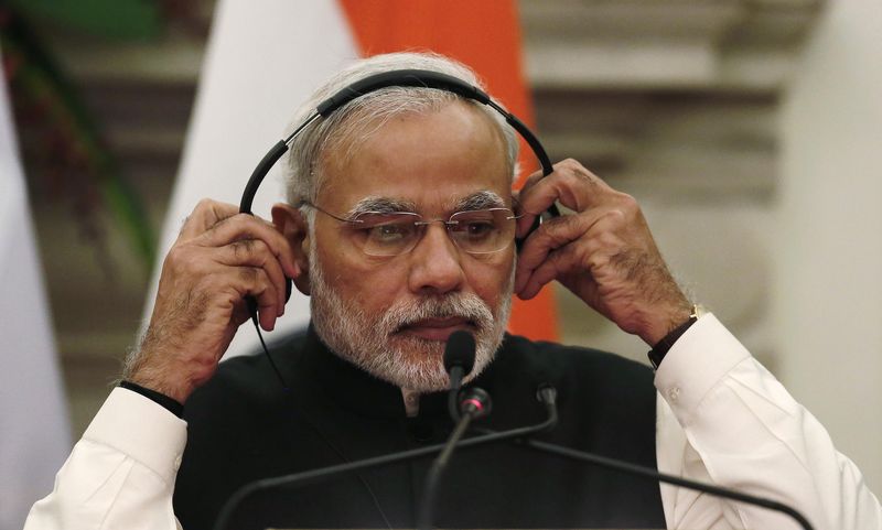© Reuters. Indian Prime Minister Modi adjusts his earphones during a joint statement with Russian President Putin after their delegation level talks at Hyderabad House in New Delhi