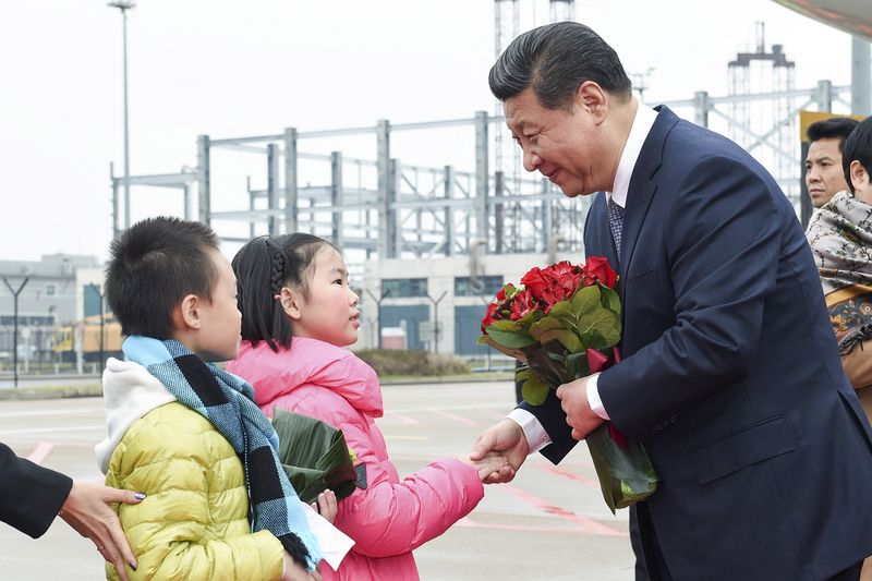 © Reuters. Chinese President Xi shakes hands with a child as he receives a bouquet upon arriving in Macau to celebrate the 15th anniversary of its handover to the mainland