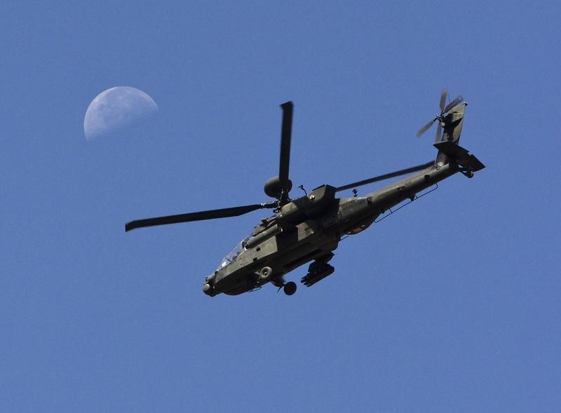 © Reuters. A U.S. Army Apache flies past the moon in the Zharay district of Kandahar province