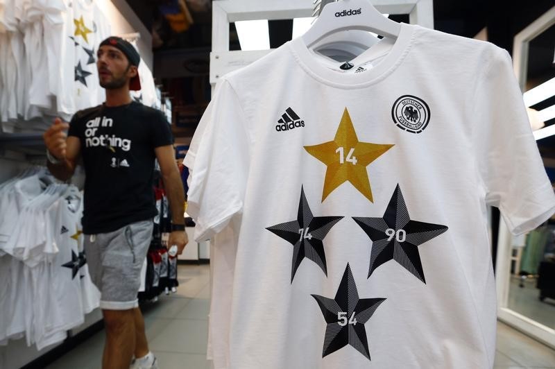 © Reuters. An employee walks past a memorabilia jersey of German national soccer team showing four stars, symbolizing the number of reached World Cup championships, in Frankfurt